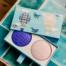 Two soaps in a decorative box on a tiled surface