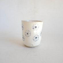 White Tumbler with blue flower pattern on beige background