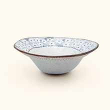 Ceramic bowl with textured blue and brown design on a white background