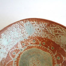 Close-up of a ceramic plate with textured surface and floral patterns