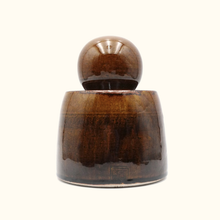 Decorative object with a cylindrical base and spherical top on a white background