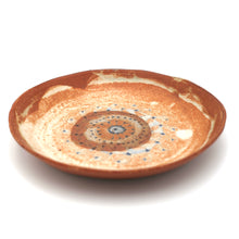 Ceramic plate with a decorative spiral pattern on a white background