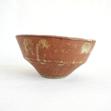 Ceramic bowl with brown glaze and white speckles on a white background