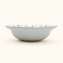 Ceramic bowl with blue floral pattern on a white background