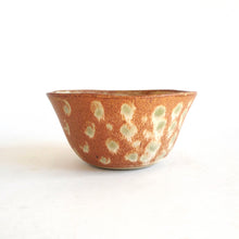 Ceramic bowl with speckled pattern on a white background