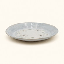 Round ceramic plate with a textured surface on a white background