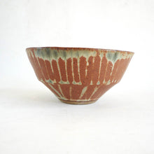 Ceramic bowl with brown and green pattern on a white background