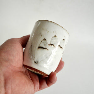 hand holding Spako Clay Wide Tumbler wildflower drawing, white glaze 