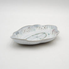 White ceramic dish with textured surface on a light gray background