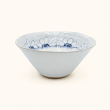 White ceramic bowl with blue floral patterns on a white background