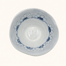 White ceramic bowl with blue floral patterns on a white background