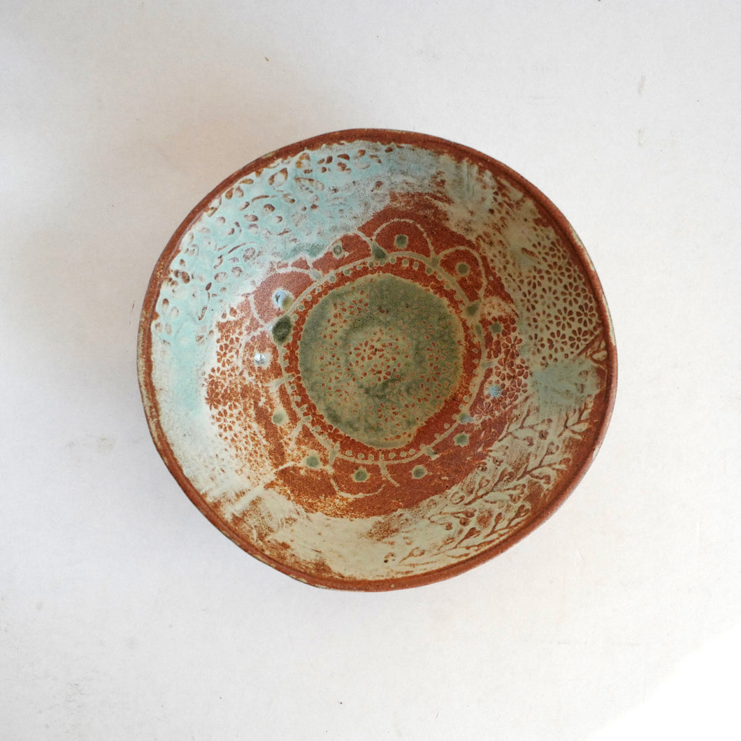 Ceramic bowl with decorative patterns on a white background
