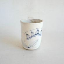 White Mug with blue flower pattern on beige background