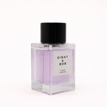 Perfume bottle with black cap and purple label on a white background