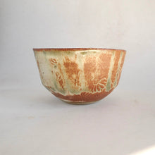 Ceramic bowl with brown and green glaze on a white background