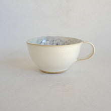 Cappuccino mug with blue flower pattern on beige background