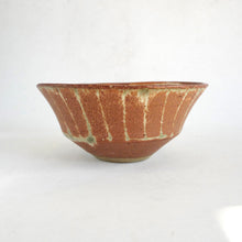 Ceramic bowl with brown and green glaze on a white background