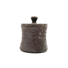 Cylindrical ceramic container with a lid on a white background