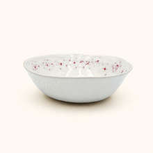 White ceramic bowl with red florals on a white background
