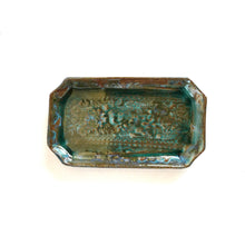 Rectangular greenish-brown ceramic dish with text on a white background