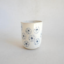 White Tumbler with blue flower pattern on beige background