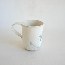 White Mug with blue flower pattern on beige background