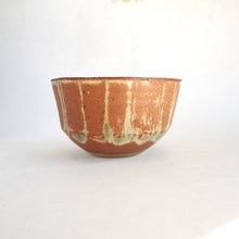 Ceramic bowl with brown and green glaze on a white background