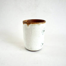 White ceramic cup with brown rim on a white background