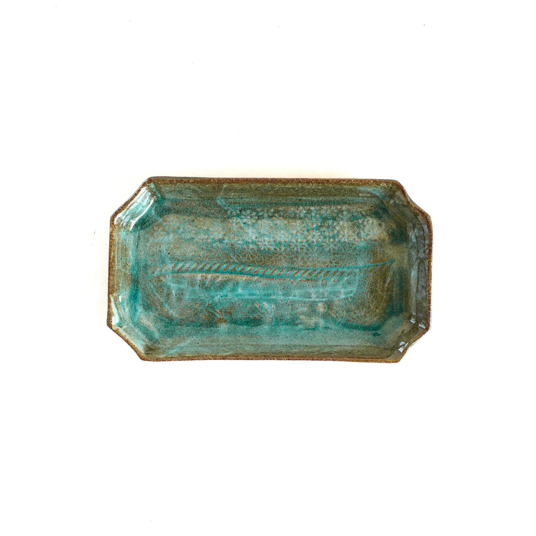 Rectangular ceramic tray with textured surface on a white background