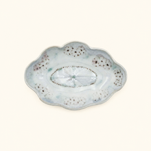 Decorative ceramic plate with scalloped edge on a white background