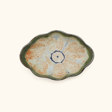 Ceramic plate with unique glaze pattern on a white background