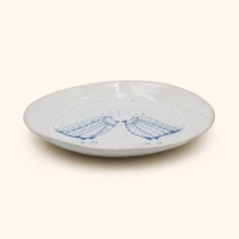 White ceramic plate with blue decorative birds on a white background