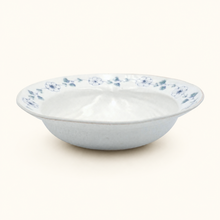 White ceramic bowl with blue floral patterns on a white background