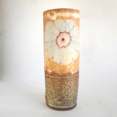 Cylindrical ceramic vase with floral design on a white background
