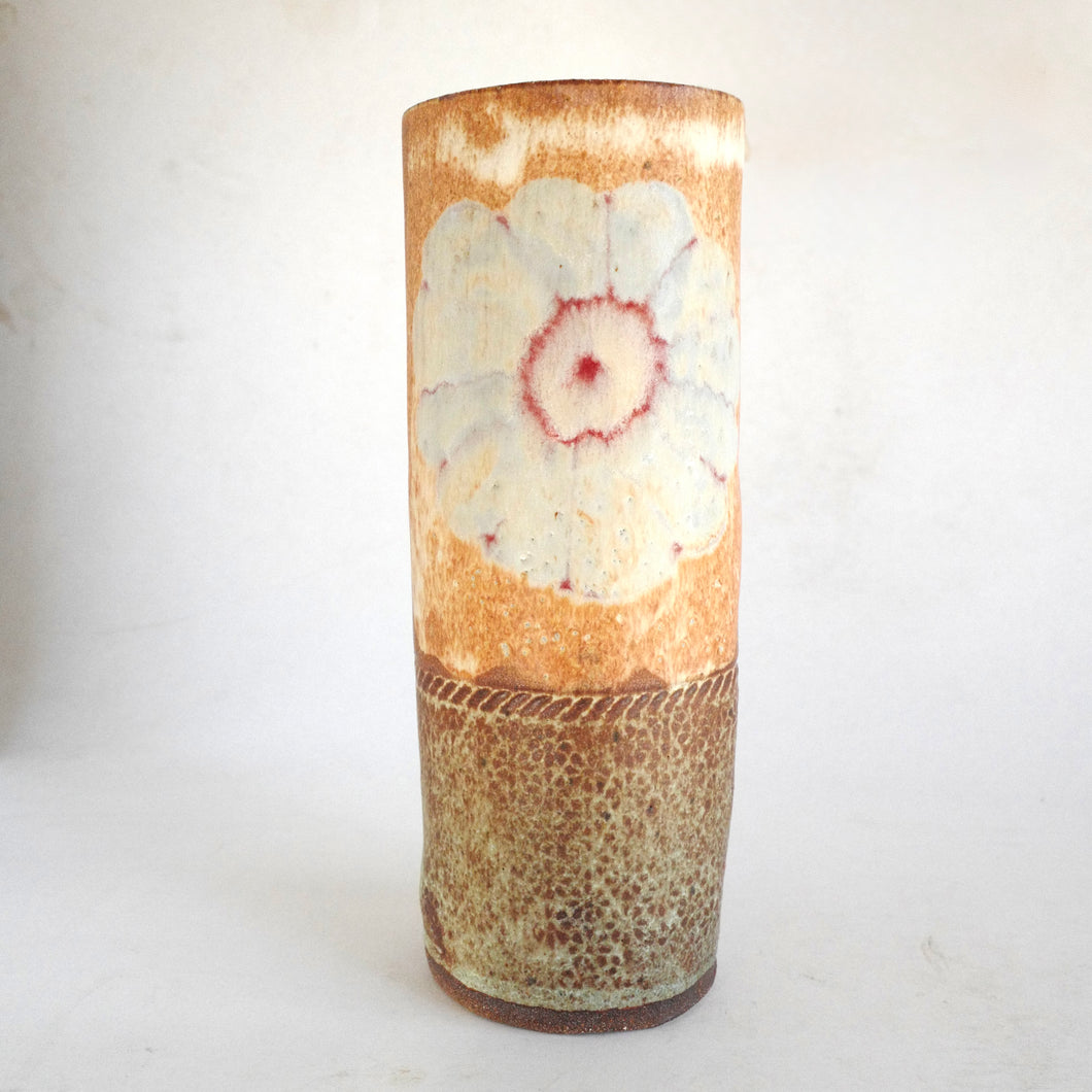 Cylindrical ceramic vase with floral design on a white background