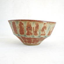 Ceramic bowl with brown and green glaze on a white background