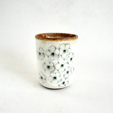 Ceramic cup with floral pattern on a white background