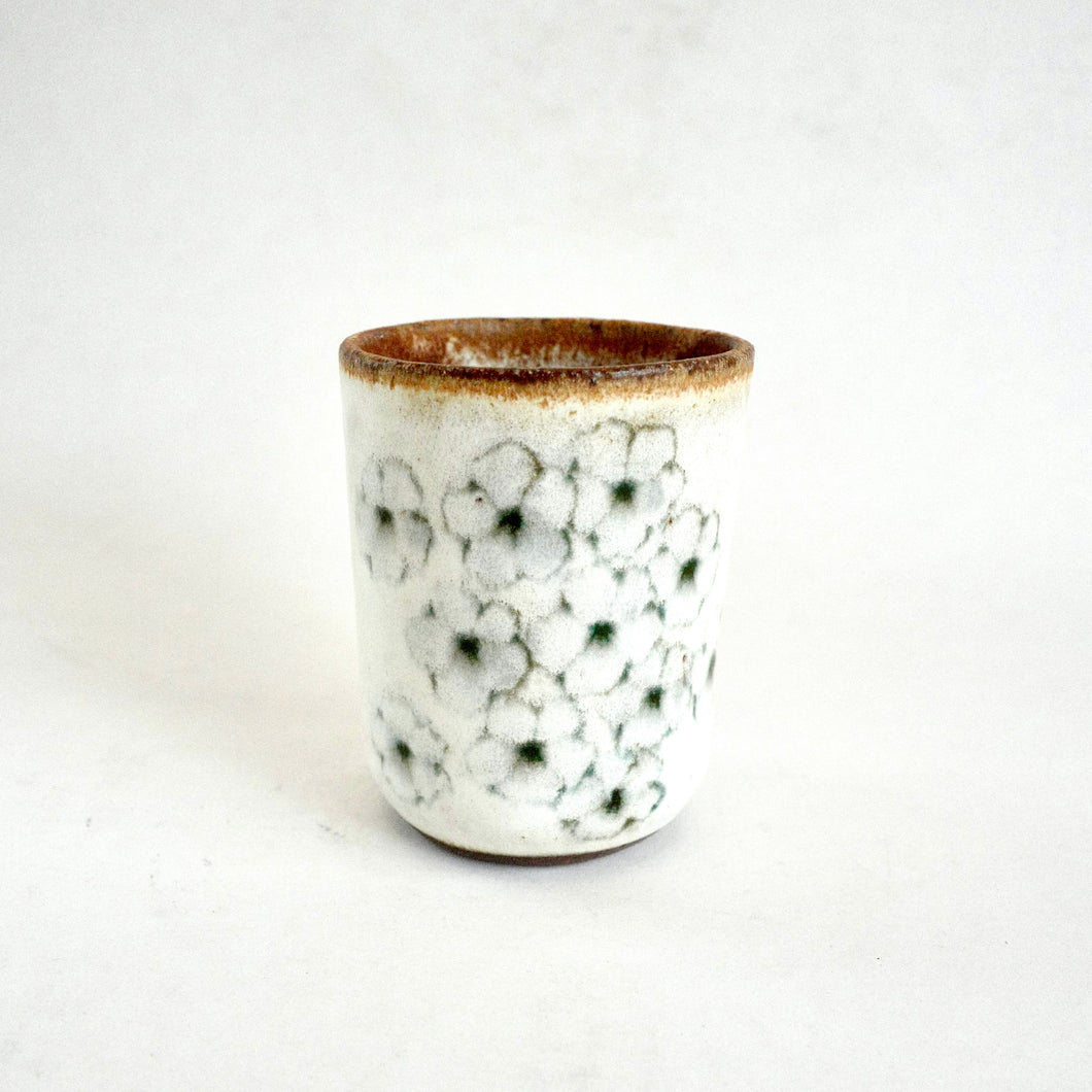 Ceramic cup with floral pattern on a white background