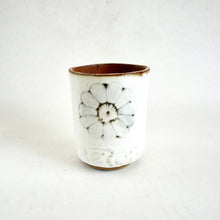 Ceramic cup with floral design on a white background