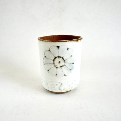 Ceramic cup with floral design on a white background