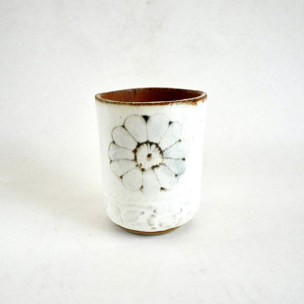 Ceramic cup with floral design on a white background