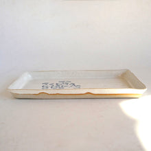 Rectangular ceramic tray with decorative patterns on a light gray background