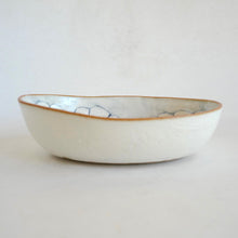 Ceramic bowl with decorative rim on a light gray background