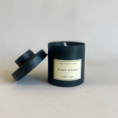 Black candle with a label on a light gray background