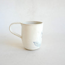 White Mug with blue flower pattern on beige background