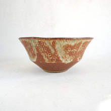 Ceramic bowl with brown and green glaze on a white background