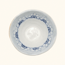 White ceramic bowl with blue floral patterns on a white background