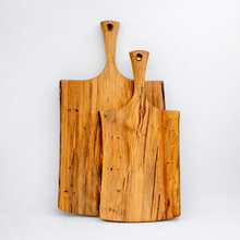 Two wooden cutting boards with handles on a light gray background