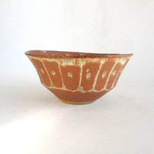 Ceramic bowl with brown and green glaze on a white background