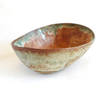 Ceramic bowl with brown and green glaze on a white background
